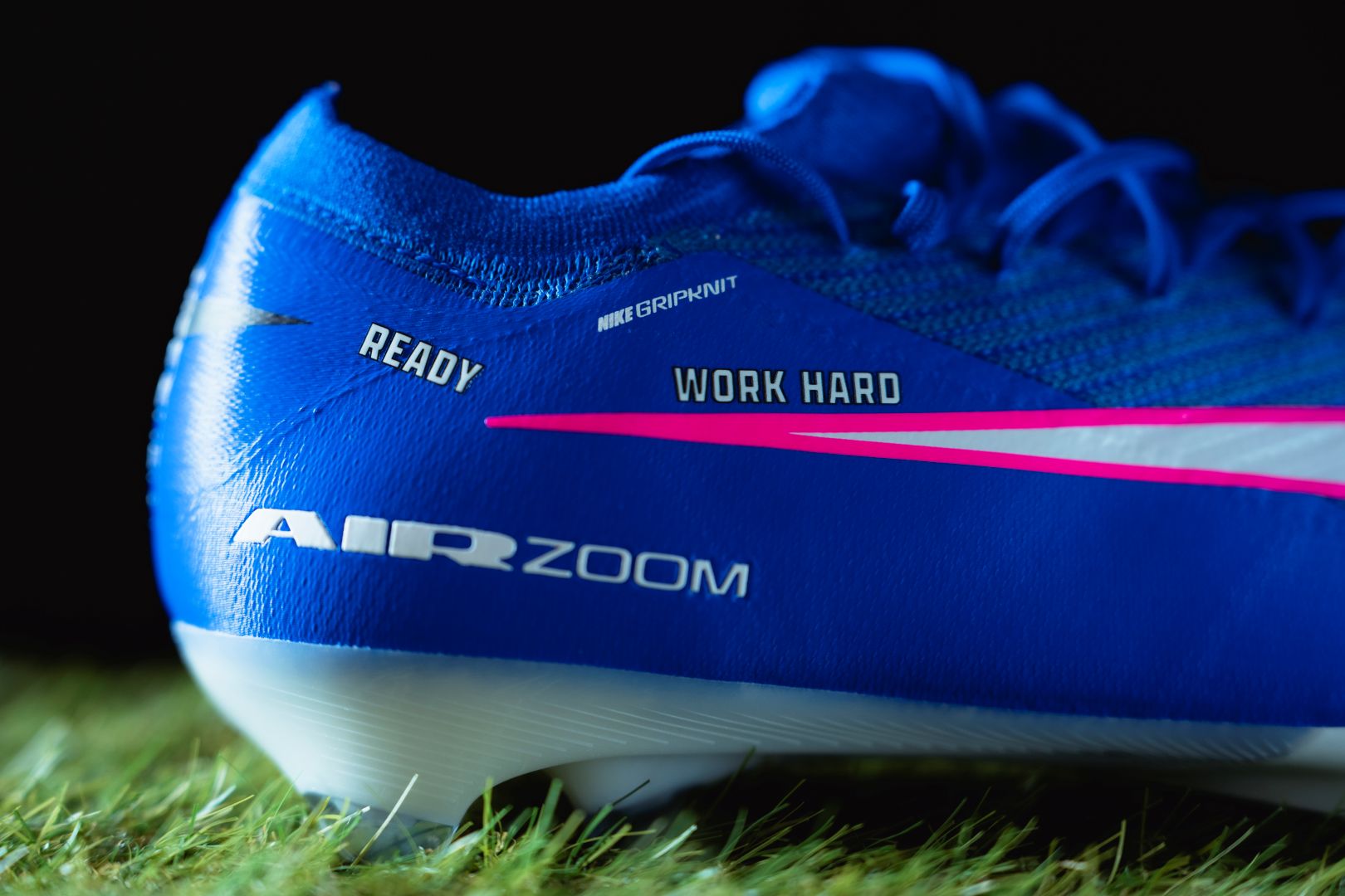 Blue sports shoe with motivational text on grass