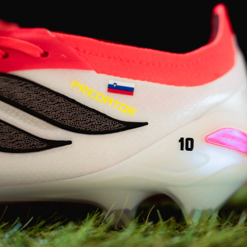 Close-up of a soccer shoe with visible personalized flag decal
on grass